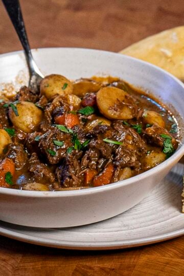 A hot bowl of beef stew with a side of cornbread.