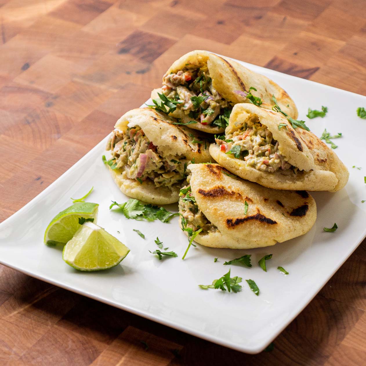 Arepas stuffed with turkey sit on a white plate
